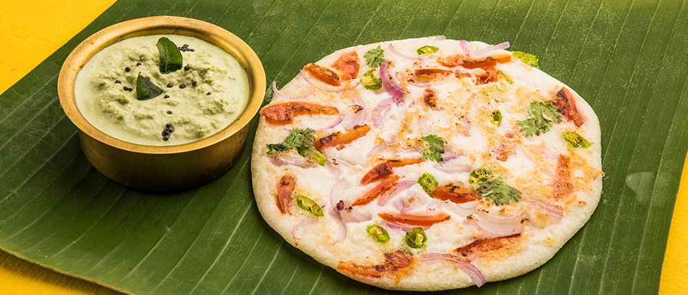 Butter-spread uttapam on breakfast plate